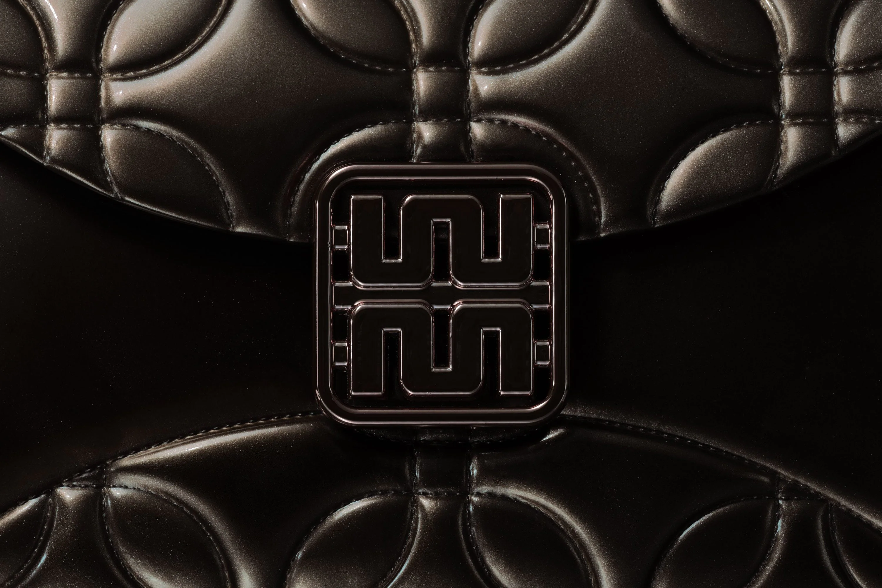 The monogram as a clasp on quilted black leather